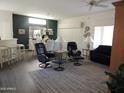 Comfortable living room with two swiveling easy chairs, a neutral area rug, and open access to the dining area at 15104 W Pinehurst W Ln, Surprise, AZ 85374