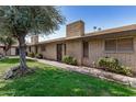 View of brick condo exterior with a well-maintained lawn, mature trees, and sidewalks leading to each unit at 2015 E Southern Ave # 2, Tempe, AZ 85282
