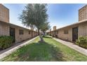 Exterior showing walkway between brick condo units with mature trees and maintained lawns and a blue sky above at 2015 E Southern Ave # 2, Tempe, AZ 85282