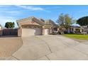 Spacious driveway leads to a well-maintained home with a three-car garage and desert landscaping at 20331 N Fletcher Way, Peoria, AZ 85382