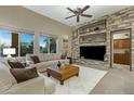 Living room with a stone fireplace, built-in shelves, and large windows offering plenty of natural light at 20331 N Fletcher Way, Peoria, AZ 85382