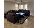 Inviting living room featuring tile floors, a ceiling fan, and a comfortable floral sofa set at 25766 W Valley View Dr, Buckeye, AZ 85326