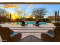 Relaxing outdoor patio with lounge chairs, offering views of the pool and landscaped backyard at 27020 N 14Th Ln, Phoenix, AZ 85085