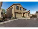 Exterior of tan two-story home with garage, arched entryway, and desert landscaping at 291 N Scott Dr, Chandler, AZ 85225