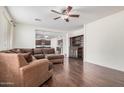 Spacious living room featuring a brown sectional sofa, dark wood floors, and a built-in cabinet at 3938 E Morrison Ranch Pkwy, Gilbert, AZ 85296