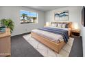 Cozy bedroom features a comfortable king bed, stylish decor, and a bright window overlooking the outdoors at 4237 E Clovis Ave, Mesa, AZ 85206