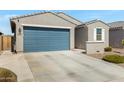 Single-story home with blue garage door, stucco siding, desert landscaping, and long concrete driveway at 5642 W Rainwater Dr Dr, Laveen, AZ 85339