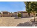 Home featuring a long brick driveway and well-maintained landscaping at 7215 W Union Hills Dr, Glendale, AZ 85308