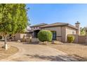 Charming home featuring an arched entrance, manicured bushes, and beautiful masonry accents at 7215 W Union Hills Dr, Glendale, AZ 85308
