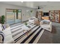 Bright living room featuring neutral decor, plush seating, and sliding glass doors to the backyard at 8886 S 256Th Dr, Buckeye, AZ 85326