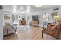 Bright living room with laminate floors, neutral walls, ceiling fans, and open doorways to other rooms at 100 Swilling Ave, Wickenburg, AZ 85390