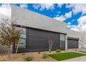 Contemporary home showcasing a gray design, expansive windows, and xeriscaped landscaping for low-maintenance appeal at 10302 E Utah Ave, Mesa, AZ 85212