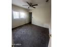 Bedroom with neutral walls, carpeted floor, and a ceiling fan, creating a calming atmosphere at 11521 W Charter Oak Rd, El Mirage, AZ 85335