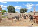 Backyard patio with a charming fireplace feature, outdoor seating, and privacy wall at 12534 W Ashwood Dr, Sun City West, AZ 85375