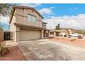 Two-story home with desert-style landscaping and driveway leading to the garage at 13153 W Clarendon Ave, Litchfield Park, AZ 85340