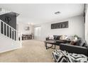 Spacious living room with neutral carpet and gray couches, and staircase at 13153 W Clarendon Ave, Litchfield Park, AZ 85340