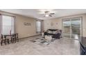 Comfortable living room area with tile flooring, sofa, and sliding glass door at 13612 W Desert Moon Way, Peoria, AZ 85383