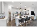 Modern kitchen featuring white cabinets, stainless steel appliances, and a stylish island with seating at 17162 W Corrine Dr, Surprise, AZ 85388