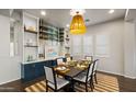 Beautiful dining area featuring built-in storage, modern lighting, and large windows for ample natural light at 17505 N 96Th Way, Scottsdale, AZ 85255