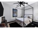 Cozy bedroom with a four-poster bed, ceiling fan and stylish decor at 20745 N Verbena Ln, Maricopa, AZ 85138