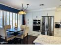 Bright kitchen with stainless steel refrigerator, double oven, and breakfast nook at 2542 S Rowen St, Mesa, AZ 85209