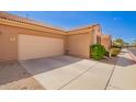 Side angle view of the exterior of a home featuring a two car garage and desert landscaping at 2565 S Signal Butte Rd # 8, Mesa, AZ 85209