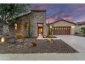 Inviting stone home with desert landscaping, front entryway, and spacious garage at 28516 N 128Th Dr, Peoria, AZ 85383