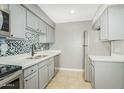 Well lit kitchen with stainless steel appliances, modern cabinets, and mosaic tile backsplash at 3402 N 32Nd St # 116, Phoenix, AZ 85018