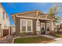 Attractive home with tidy landscaping and a cozy front porch sitting area at 4061 N Point Ridge Rd, Buckeye, AZ 85396