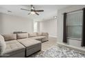 Light and airy living room featuring a sectional sofa and ceiling fan at 4170 N 154Th Dr, Goodyear, AZ 85395