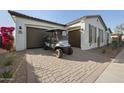 Home featuring a two-car garage and a golf cart parked in the driveway at 5340 S Sabrina --, Mesa, AZ 85212