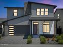 Charming two-story home featuring a gray garage door, modern design, and manicured landscaping at 6735 N 9Th Dr, Phoenix, AZ 85013