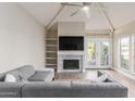 Cozy living room features a fireplace, a ceiling fan, and French doors leading to a balcony at 7675 E Mcdonald Dr # 225, Scottsdale, AZ 85250