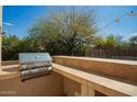 Built-in stainless steel grill with stone counter in outdoor kitchen and lush green backyard at 7693 E Via Del Sol Dr, Scottsdale, AZ 85255