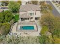 Backyard pool area featuring a secured fence, lounge chairs, and an outdoor seating area at 7693 E Via Del Sol Dr, Scottsdale, AZ 85255