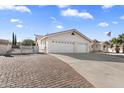 Spacious home with a three-car garage and brick driveway; perfect for parking multiple vehicles at 825 N Sierra Vista Dr, Wickenburg, AZ 85390