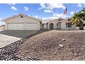 Charming single-story home featuring a well-manicured xeriscaped yard, three-car garage and an American flag at 825 N Sierra Vista Dr, Wickenburg, AZ 85390