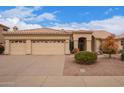 Charming single-story home with a tile roof, desert landscaping, and a spacious three-car garage at 9104 E Hillery Dr, Scottsdale, AZ 85260