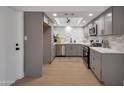 Modern kitchen with sleek gray cabinets, stainless steel appliances, stylish backsplash, and quartz countertops at 924 W Boxelder Pl, Chandler, AZ 85225