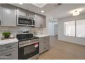 Updated kitchen featuring stainless steel microwave and range oven, and gray cabinets over a light, wood floor at 924 W Boxelder Pl, Chandler, AZ 85225