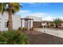 Single-story home with desert landscaping and brick paved drive leading to gated entry at 10406 E Silvertree Dr, Sun Lakes, AZ 85248