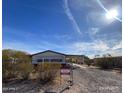 Wide angle shot of a single story home featuring desert landscaping and a covered parking area at 10997 N Hualapai Dr, Casa Grande, AZ 85122