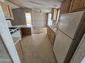 Functional kitchen featuring wood cabinets, a dual basin sink, and an adjacent dining area with ceiling fan at 10997 N Hualapai Dr, Casa Grande, AZ 85122