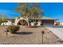 Charming house featuring a brick archway, desert landscaping, a mature shade tree and a two-car garage at 11138 W Hatcher Rd, Sun City, AZ 85351