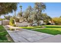 Wide driveway leading to a charming home with mature trees and a brick walkway at 1129 W Holly St, Phoenix, AZ 85007