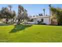 Single story home with white brick, a blue door, and lush green front lawn at 1129 W Holly St, Phoenix, AZ 85007