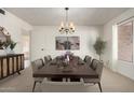 Elegant dining room featuring a modern chandelier, ample seating, and a large window for plenty of natural light at 11451 S Half Moon Dr, Phoenix, AZ 85044