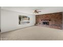 Bright living room features a cozy fireplace, a large window, and neutral-toned carpeting at 11451 S Half Moon Dr, Phoenix, AZ 85044