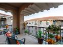 Balcony furnished with a table and chairs, with colorful potted plants and open-air views at 11640 N Tatum Blvd # 3074, Phoenix, AZ 85028