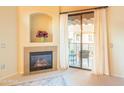 Cozy living room featuring a fireplace, balcony access, and neutral color palette at 11640 N Tatum Blvd # 3074, Phoenix, AZ 85028